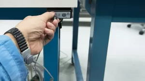 Employee plugging in an ESD wrist strap to a grounding port, demonstrating the human element in ESD protection.